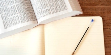 Ist das Vertriebsmodell Free2Play wettbewerbswidrig? 3 Schlüsselwörter: Vertriebsmodell, Free2Play.
Geänderte Beschreibung: Ein Holztisch mit einem offenen Buch und einem Stift, der das Free2Play-Vertriebsmodell erkundet.